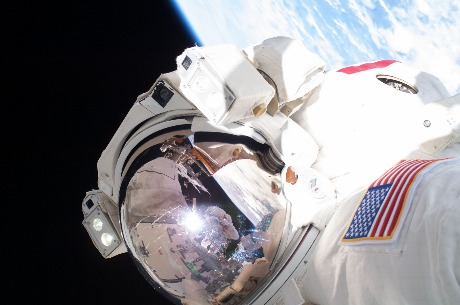 Крис Кэссиди на фоне Земли во время выхода в открытый космос